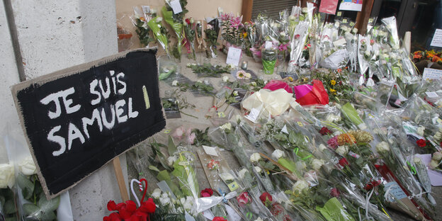 Blumen und ein Schild mit der Aufschrift "Je suis Samuel" Blumen und ein Schild mit der Aufschrift "Je suis Samuel"