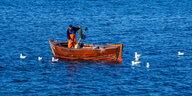 Ein Fischer leert auf der Ostsee zwischen den Inseln Rügen und Hiddensee in einem kleinen Holzboot seine Fangreusen