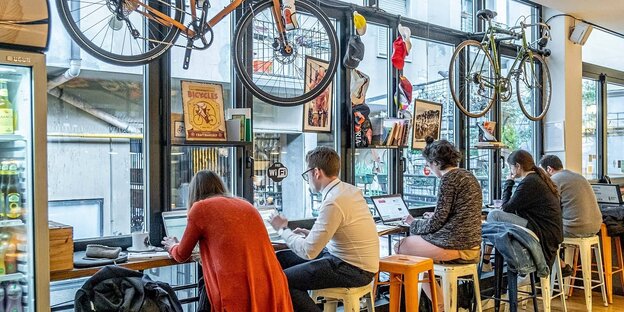 Menschen arbeiten an Laptops in einem Café