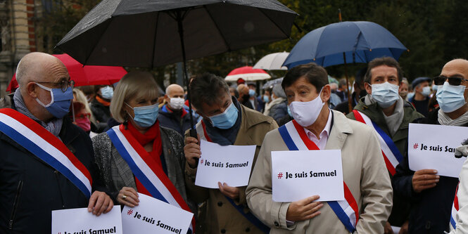 Menschen stehen mit Schildern mit der Aufschrift "Ich bin Samuel" auf der Straße