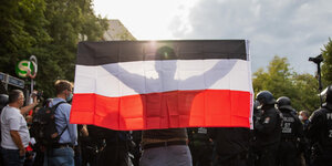 Ein Mann hält eine Reichsflagge bei einem Protest gegen die Corona-Maßnahmen vor der russischen Botschaft in Berlin.