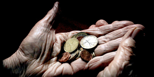 Hände einer alten Frau halten Geldmünzen