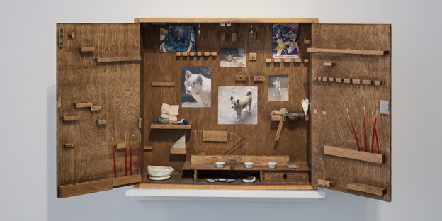 Ein Holzschränkchen gefüllt mit Bildern der Künstlerin Lauryn Youden