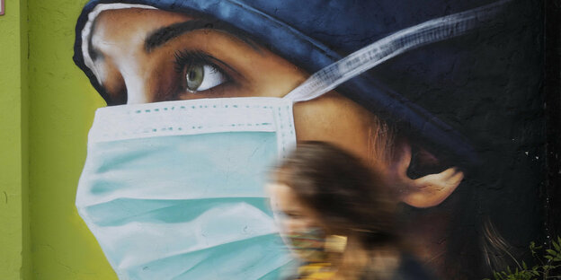 Wandmaerei, das Motiv: eine Frau mit Atemschutzmaske