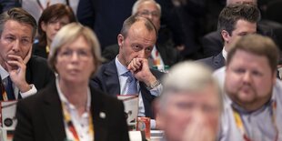 Friedrich Merz sitz zwischen Deligierten der CDU