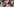 Eine Frau mit Mundschutzmaske in einer Menschenmenge fasst sich an den Kopf