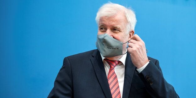 Innenminister Horst Seehofer zieht sich die Maske ab