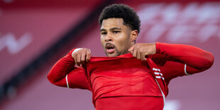 Serge Gnabry in Großaufnahme zieht sich das Trikot im Stadion bis zum Kinn hoch