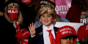 Ein Kind trägt eine Perücke, die aussieht wie die Frisur von Donald Trump
