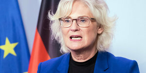 Christine Lambrecht, Politkerin, spricht auf einer Pressekonferenz - im Hintergrund ist die Fahne Deutschlands und der EU zu sehen
