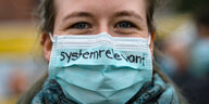 Frau mit Mundschutz mit der Aufschrift "systemrelevant"
