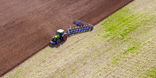 Luftaufnahme. Ein Traktor pflügt einen Acker