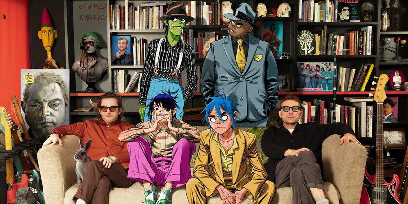 Jamie Hewlett und Damon Albarn inmitten ihrer Gorlliza-Cartoonfiguren. Neben Hewlett sitzt ein Kaninchen