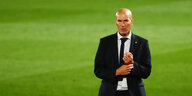Zinédine Zidane im Anzug, im Hintergrund der grüne Rasen