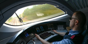 Ein Lokführer sitzt im Cockpit eines ICE3.