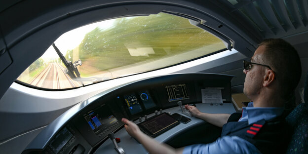 Ein Lokführer sitzt im Cockpit eines ICE3.