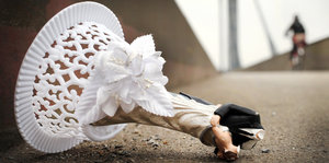 Die Statuette eines Brautpaars ohne Köpfe liegt am Boden