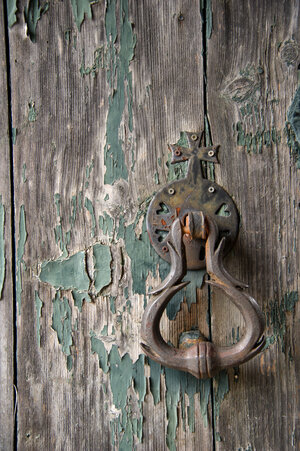 Eine alte Tür mit einem Türklopfer aus Metall