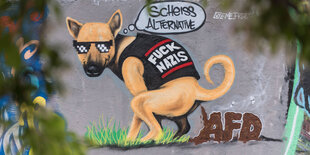 EIn Graffiti auf einer Wand: Ein Hund mit Sonnenbrille kackt den braunen Schriftzug AfD auf den Boden, er denkt mit einer Comic-Sprechblase: "Scheiß Alternative!"