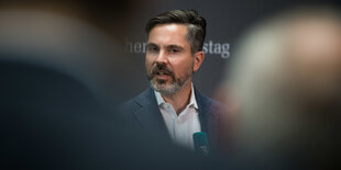 Fabio de Masi vor einem Schriftzug des Deutschen Bundestags