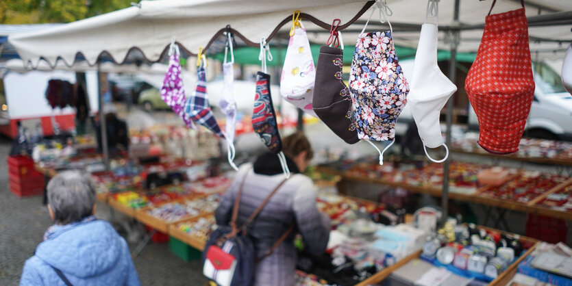 Masken hängen zum Verkauf an einem Marktstand