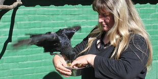 Eine Frau hat einen Vogel auf dem Arm