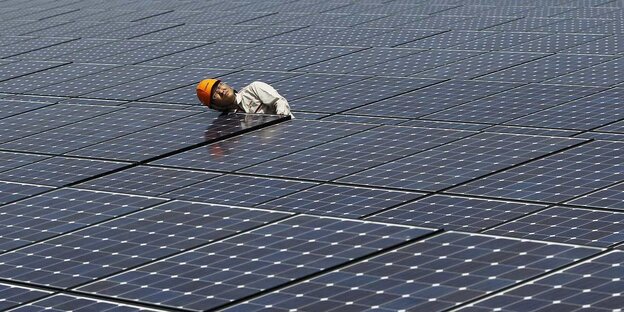Ein Arbeiter zwischen Solarzellen
