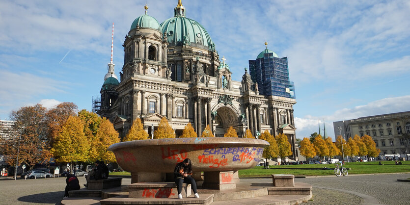 Eine große Granitschale im Lustgarten am Alten Museum ist großflächig beschmiert. Im Hintergrund ist der Dom zu sehen.