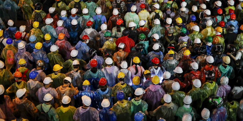 Aktivisten in Regencapes bei einem Protestmarsch in Bangkok