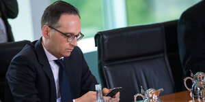 Bundesjustizminister Maas mit einem Smartphone