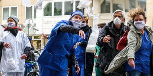 Pfleger und Pflegerinnen protestieren vorm Bundesgesundheitsministerium im Berlin