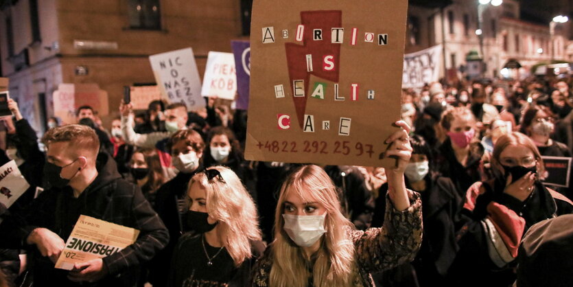 DemonstrantInnen mit Pappschildern nachts