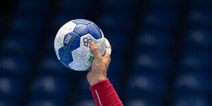 Eine Hand hält einen Handball.