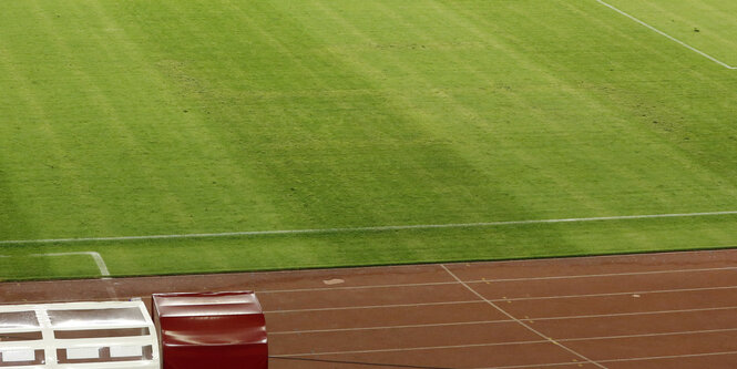 Leerer Fußballplatz, auf dem schemenhaft ein Hakenkreuz zu erkennen ist