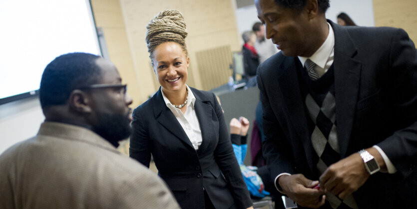 Die Bürgerrechtsaktivistin Rachel Dolezal zwischen zwei schwarze Männern