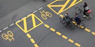 Der Radfahrer - zu sehen aus der Vogelperspektive - fahren auf einem mit gelber Farbe markierten Fahrradweg