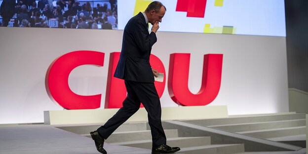 Friedrich Merz läuft an dem Logo der CDU vorbei