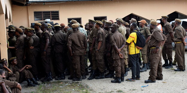 Uniformierte drängeln sich vor einem Wahllokal