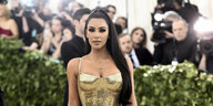 Kim Kardashian posiert in einem gold glitzernden Kleid