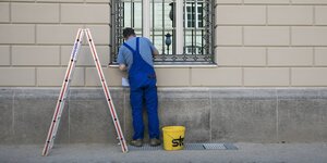 Ein Handwerker arbeitet an einem Fenster