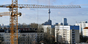 Ein Kran vor Häusern und dem Fernsehturm