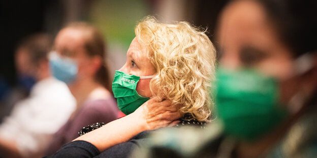 Das Foto zeigt Grünen-Delegierte mit grünem Mundschutz