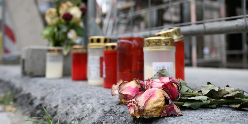 Blumen und Kerzen liegen unweit des Residenzschlosses vor einem Bauzaun an der Schlossstraße.