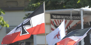 Eine Reichskriegsflagge und eine Reichsflagge werden auf einer Demonstration gezeigt.