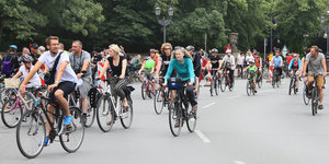Fahrradfahrer fahren über den Kreisverkehr an der Siegessäule in Berlin.