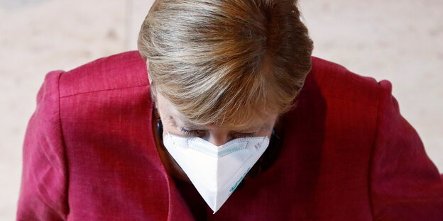 Angela Merkel mit weißer FFP2-Maske im Bundestag, stützt das Kinn auf die Hände