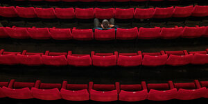 Ein einziger Mann sitz in einem großen Kinosaal