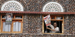Ein Saleh-Unterstützer in Sanna hält ein Foto des ältesten Sohns des ehemaligen Präsidenten Ali Abdullah Saleh aus einem Fenster.