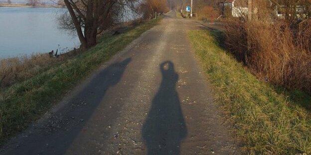Schatten von Spaziergängern an der Oder