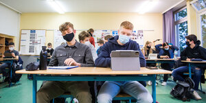 Zwei Schüler mit Mund-Nasen-Maske am Tisch